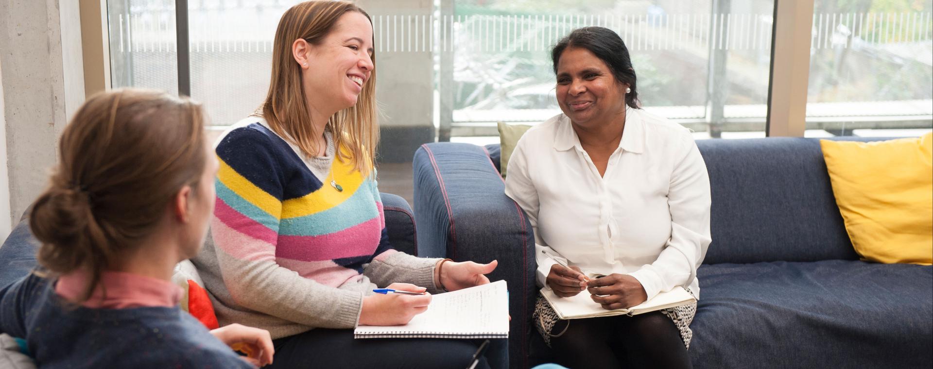 Tenants in a meeting, smiling, sitting on a sofa