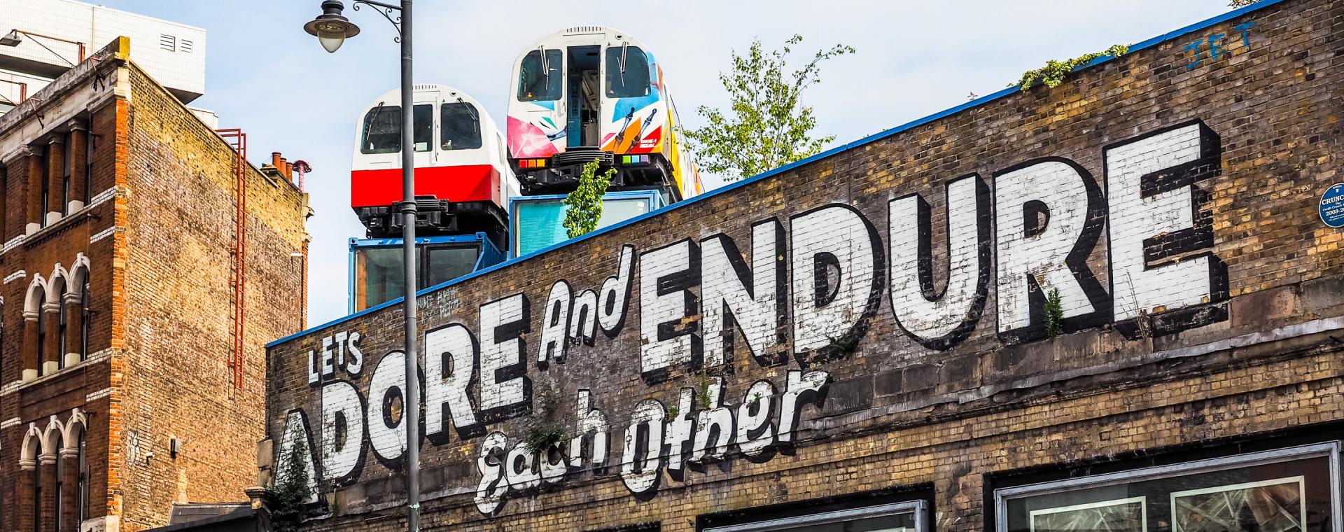 Local street art in Shoreditch, graffiti reads 'Let's adore and endure each other''