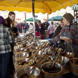 Woman wearing bandana behind olive stall