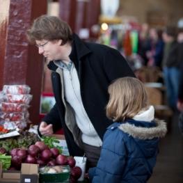 Man and small girl peruse at some red onions