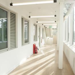 Light airy corridor looking onto Cambridge Heath Rd at The Green House, East London